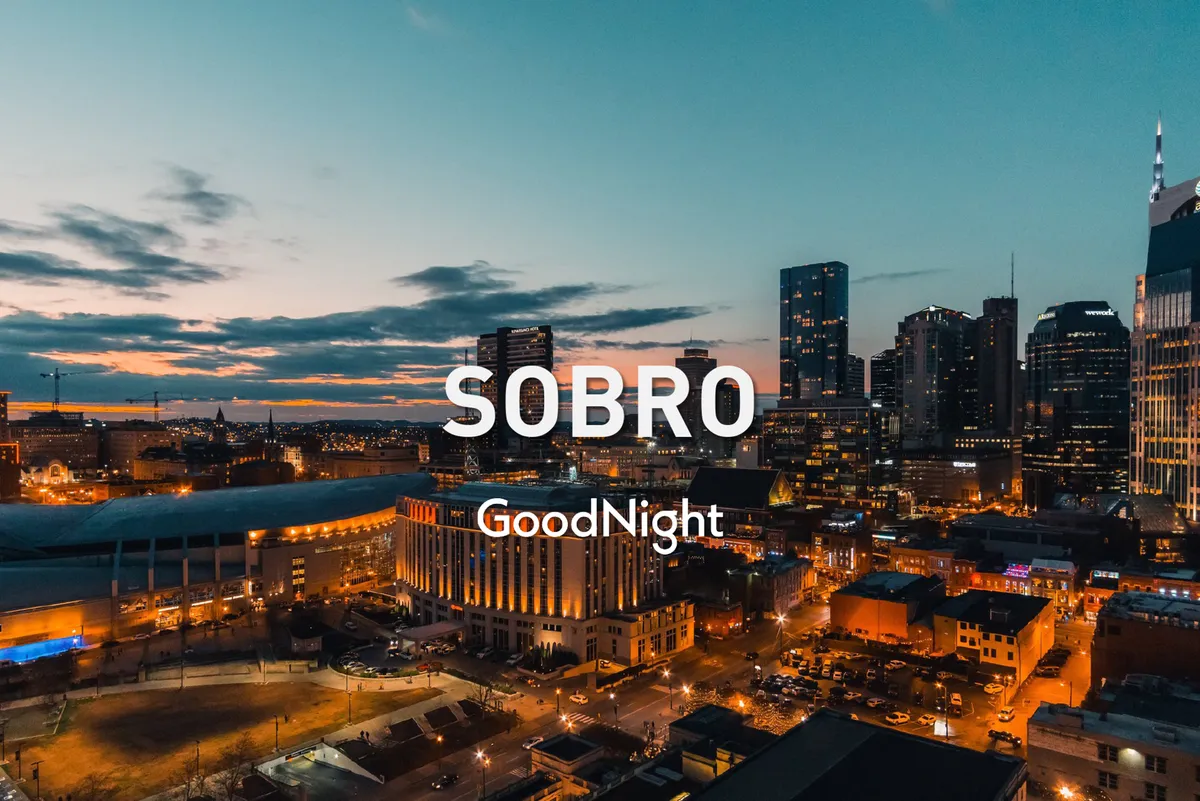 A panoramic view of the Nashville city skyline at sunset, capturing the urban energy and the vibrant, inviting atmosphere that comes alive as night falls. The glowing city lights suggest bustling nightlife and endless opportunities for entertainment and connection.