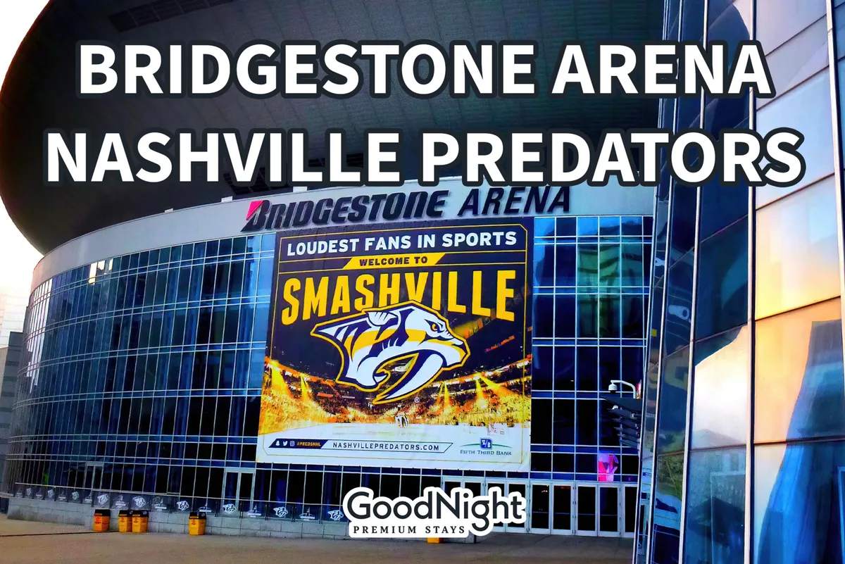 The exterior of Bridgestone Arena, featuring the recognizable Nashville Predators logo and a large advertisement banner. The arena's lively façade is illuminated, suggesting the excitement and energy of a major event or concert night.